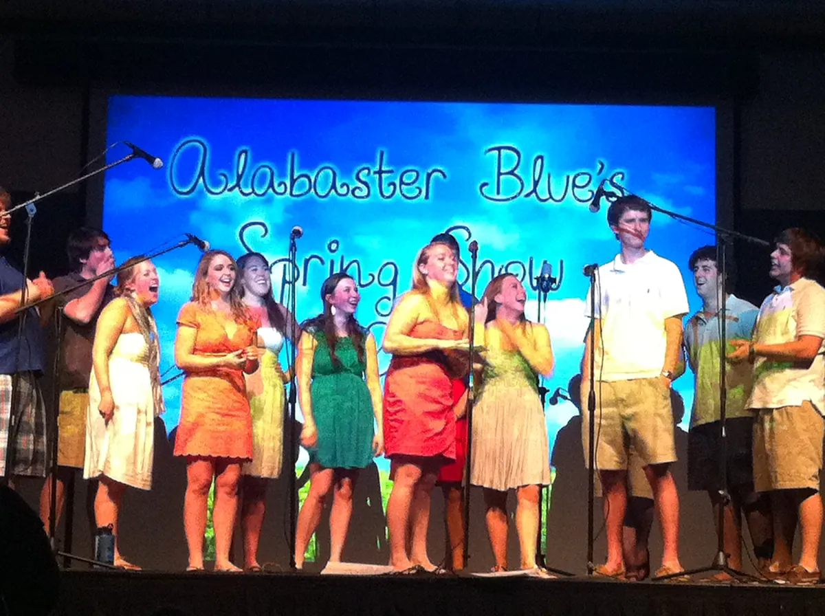 Student cast on a lit stage