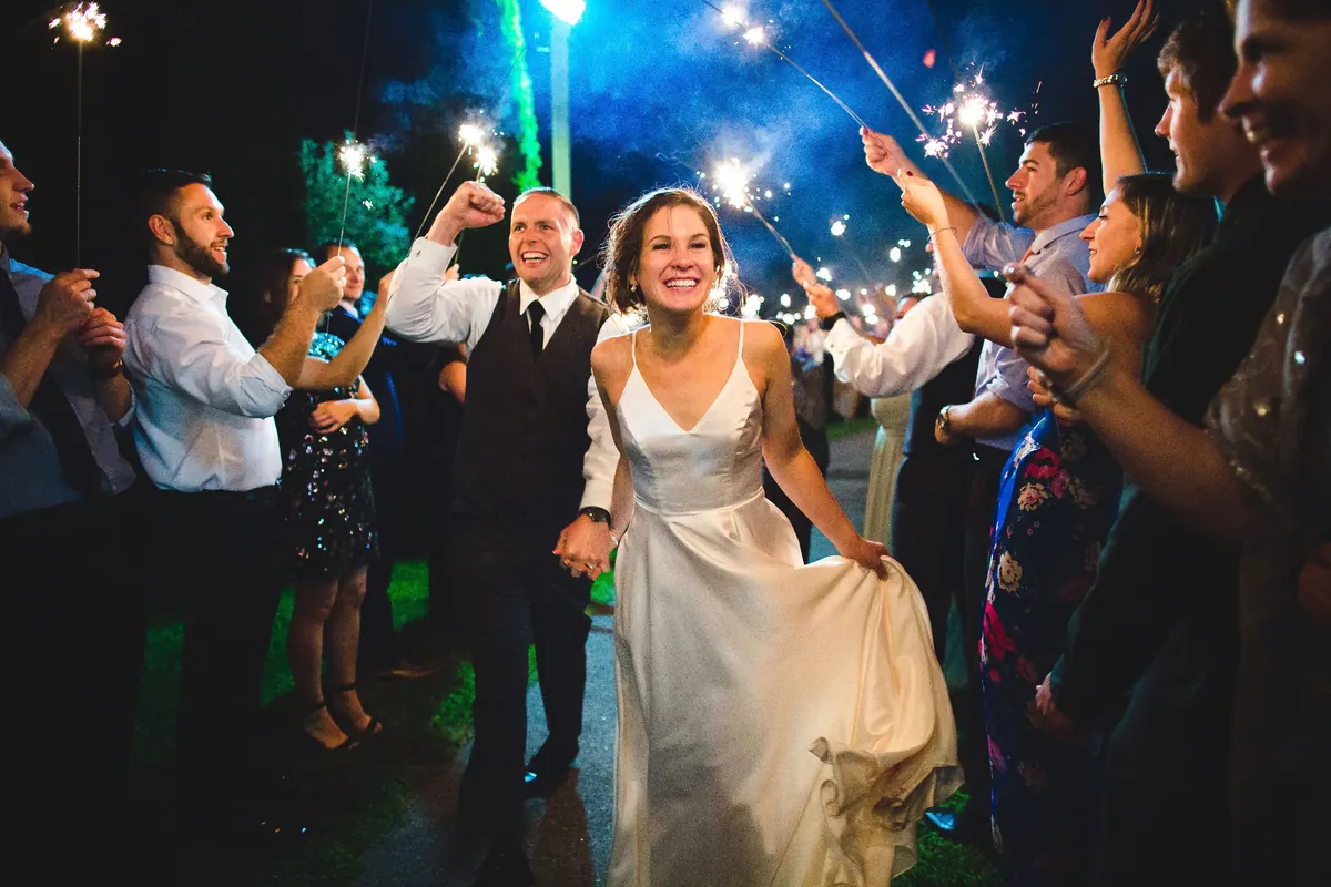 Bride dancing with guests under colored lights